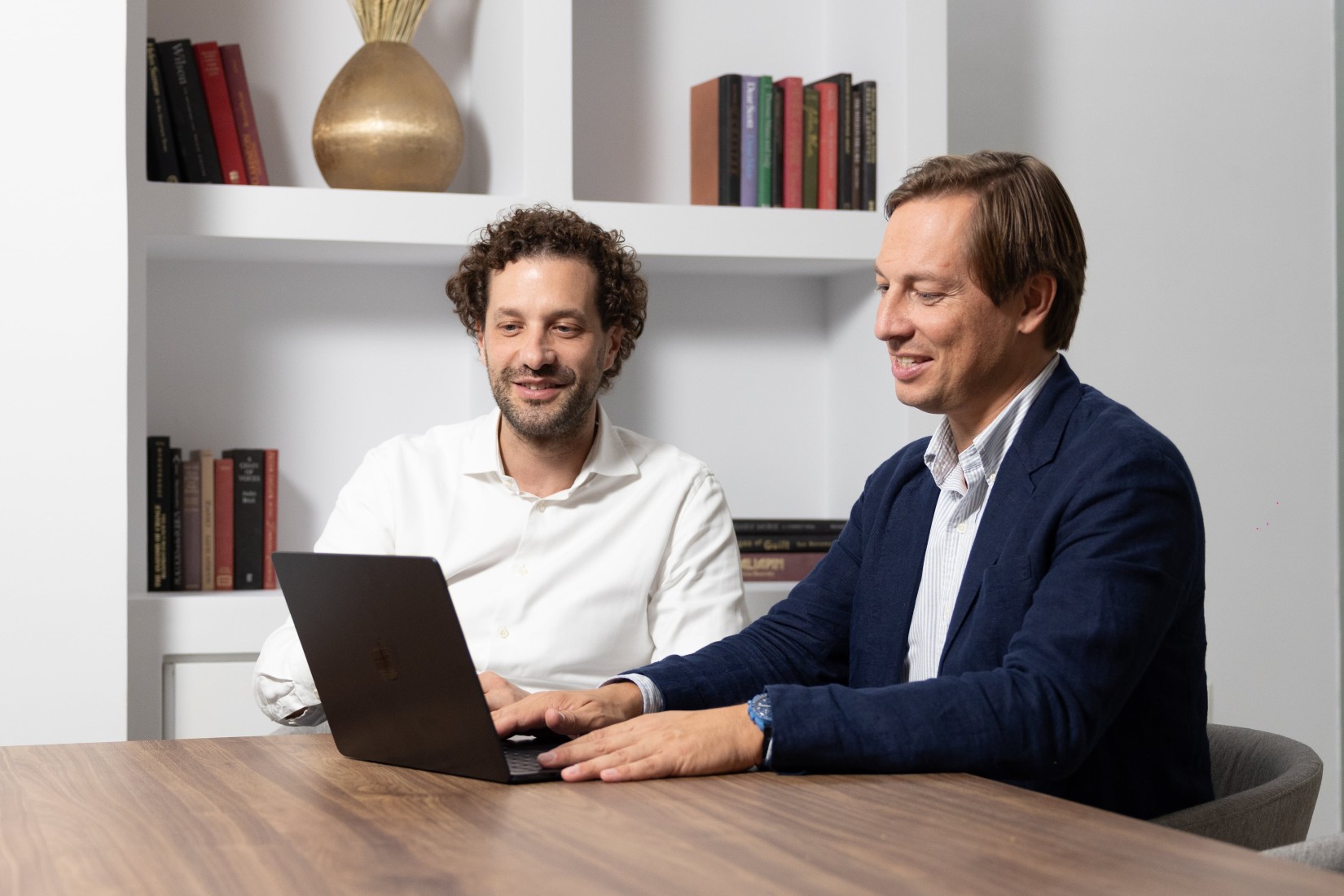 Zwei Männer schauen auf einen Laptop